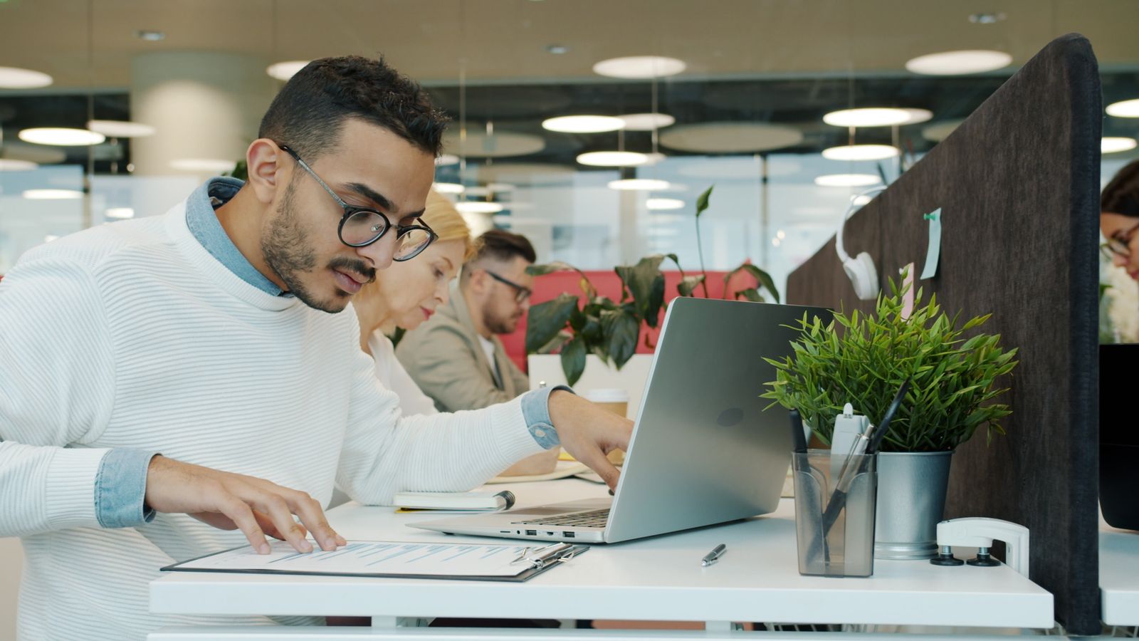 Colleagues working together on a laptop in a modern office